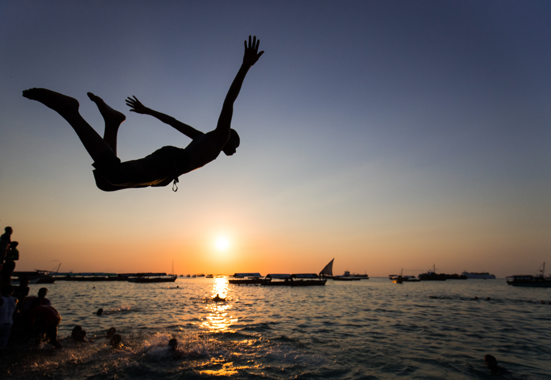 Person diving into the ocean at sunset in Zanzibar